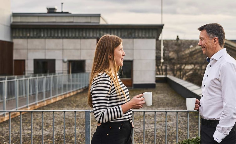 To ansatte i BN Bank står på en takterasse, illustrasjon til fastrenteinnskudd