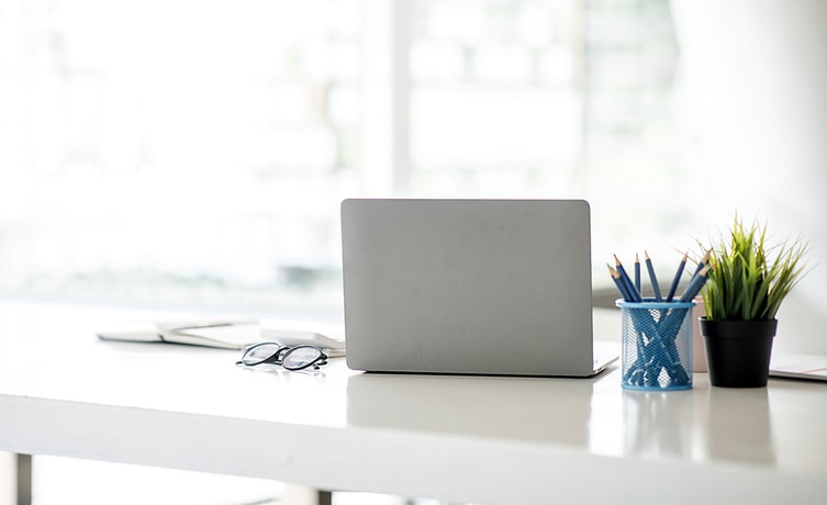 Bok, laptop, briller og blyanter på en skrivepult, til illustrasjon for problemer med innlogging