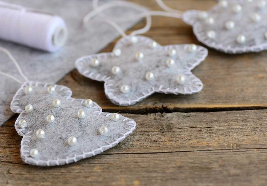 Grå julepynt med perler ligger på bordet, til illustrasjon for julegavehandel