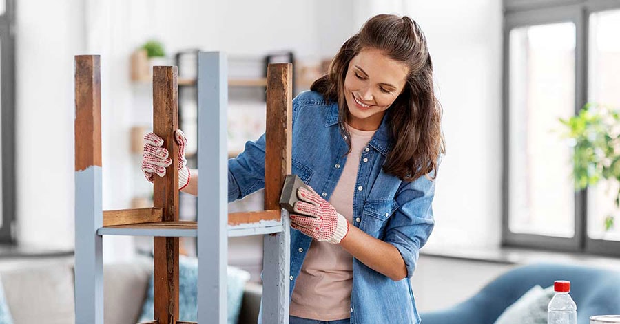 Dame pusser opp gammel krakk, til illustrasjon for miljøvennlig oppussing