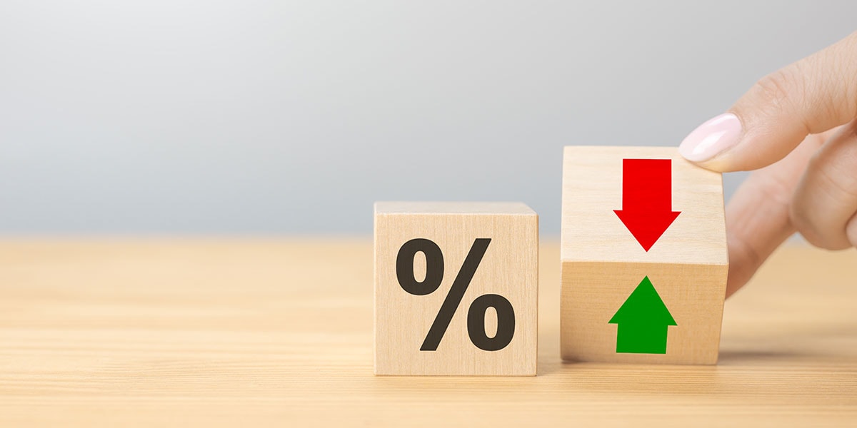 Kvinner holder en klosse med pil opp og pil ned og andre klosse med prosenttegn ved siden av, til illustrasjon for styringsrente