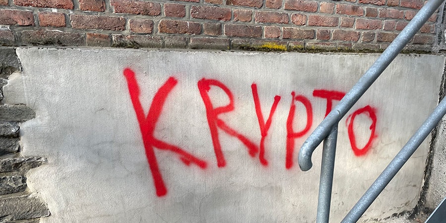 Krypto tagget med rød skrift på bygning, til illustrasjon for kryptovaluta