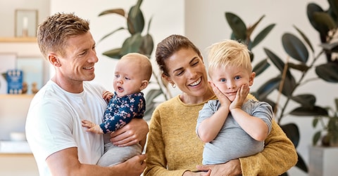 Far, baby, mor og sønn står i stua og smiler, til illustrasjon for renteendring