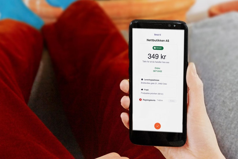 Person holder en mobiltelefon som viser vipps betaling