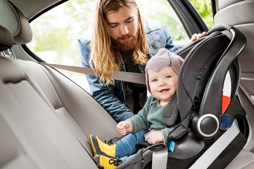 Mann sjekker bilstolen til en baby, til illustrasjon for billån