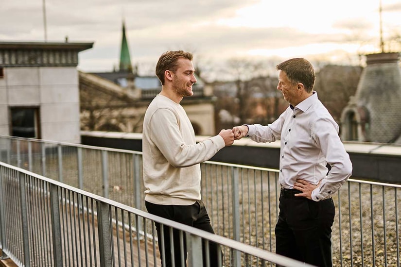 Ansatte i BN Bank ute på bankens takterasse gir hverandre en high five - illustrasjon til fastrenteinnskudd