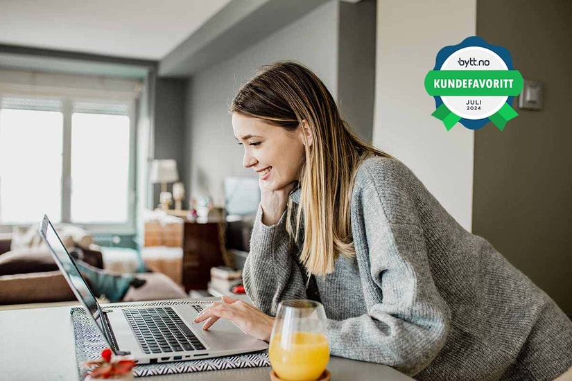 Kvinne med laptop og et glass appelsinjuice, til illustrasjon for daglig bruk