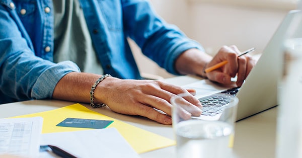 Mann sjekker nettbank på laptop, til illustrasjon for sikker netthandel