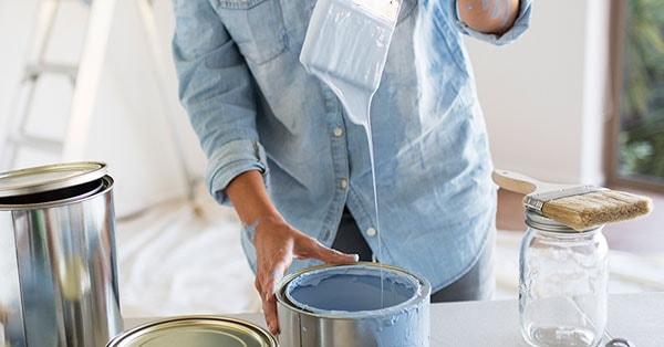 Dame dupper malingskost i malingsspann, til illustrasjon for oppussing