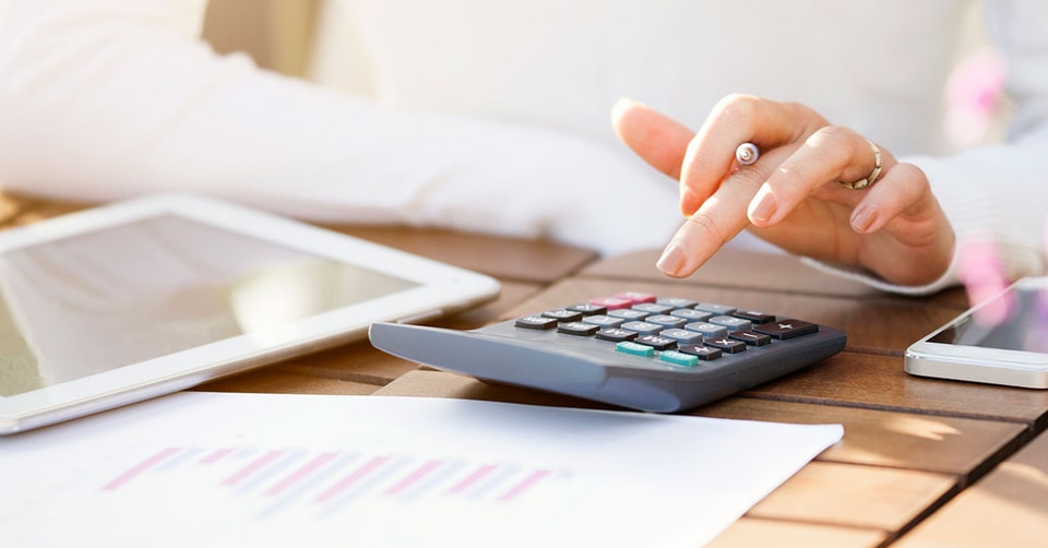 Dame bruker kalkulator for å regne, til illustrasjon for samlivsbrudd og økonomi