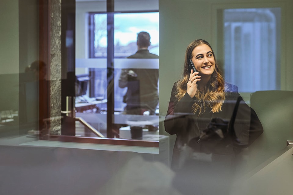 Kvinne som snakker i telefonen, mens hun vurderer fordele ved å ha en høyrentekonto