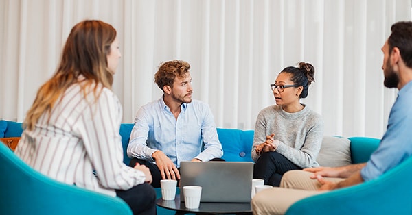 Kollegaer som sitter i sofaen og prater