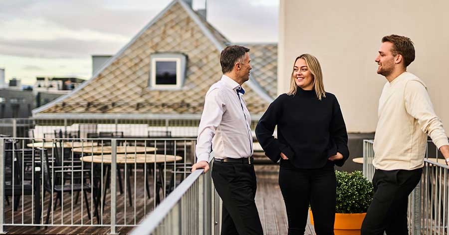 Vegar, Kine og Peter står på en balkong og snakker om boliglån